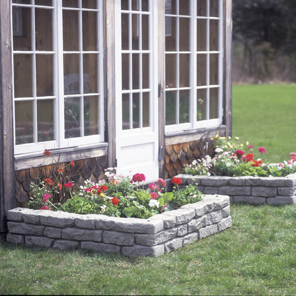 three pieces of straight rock lock assembled to make garden bed against house