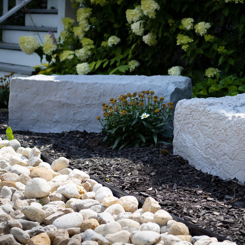 large landscape rock in grey in a garden with rock path in front