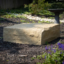 extra large landscape rock in sandstone on wood chips in a garden with bird bath